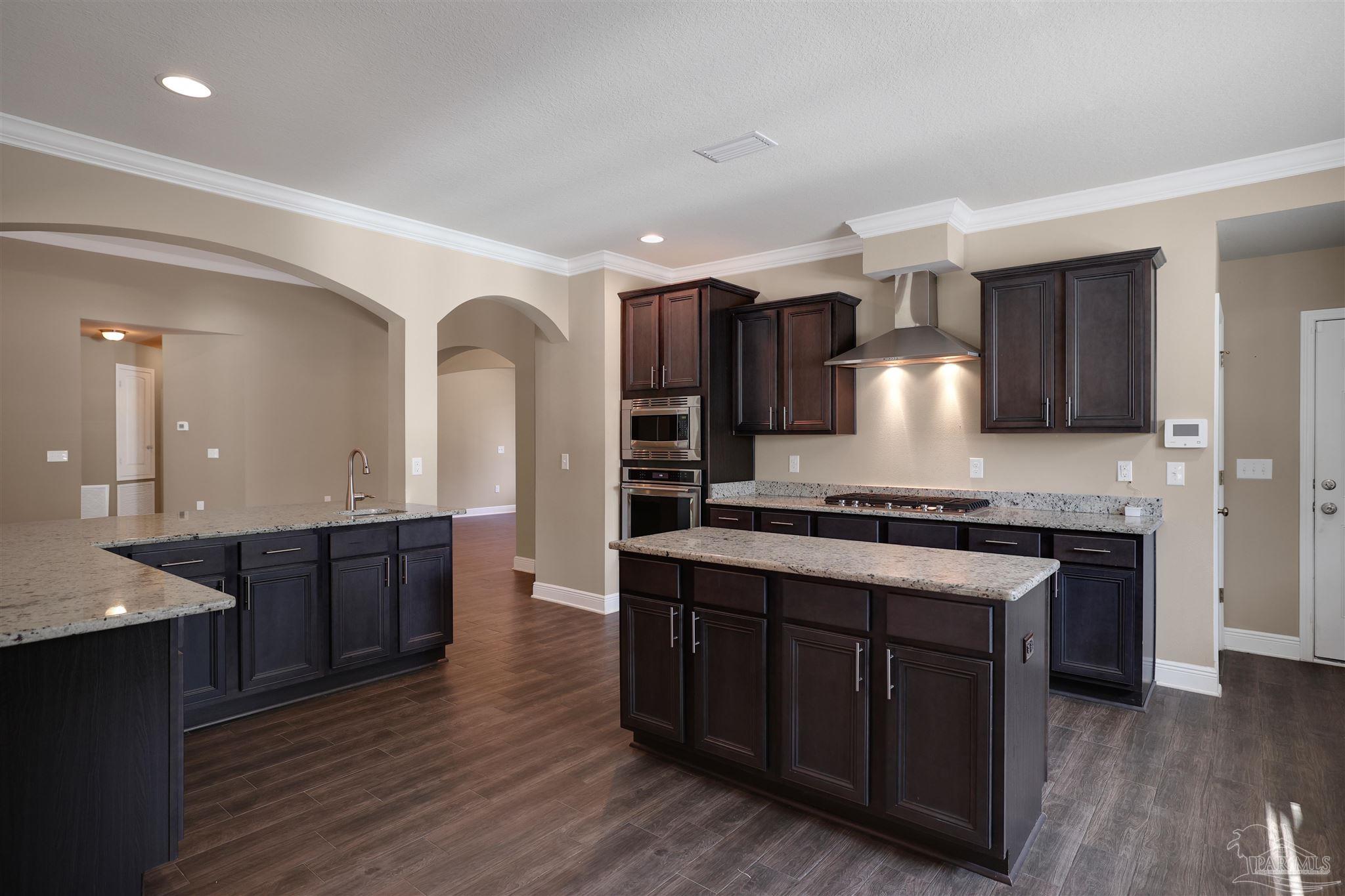 5847 Mossy Creek Lane Pace, FL 32571 - Photo 4 of 50 a large kitchen with stainless steel appliances granite countertop a stove a sink dishwasher a microwave oven and a oven with wooden floor