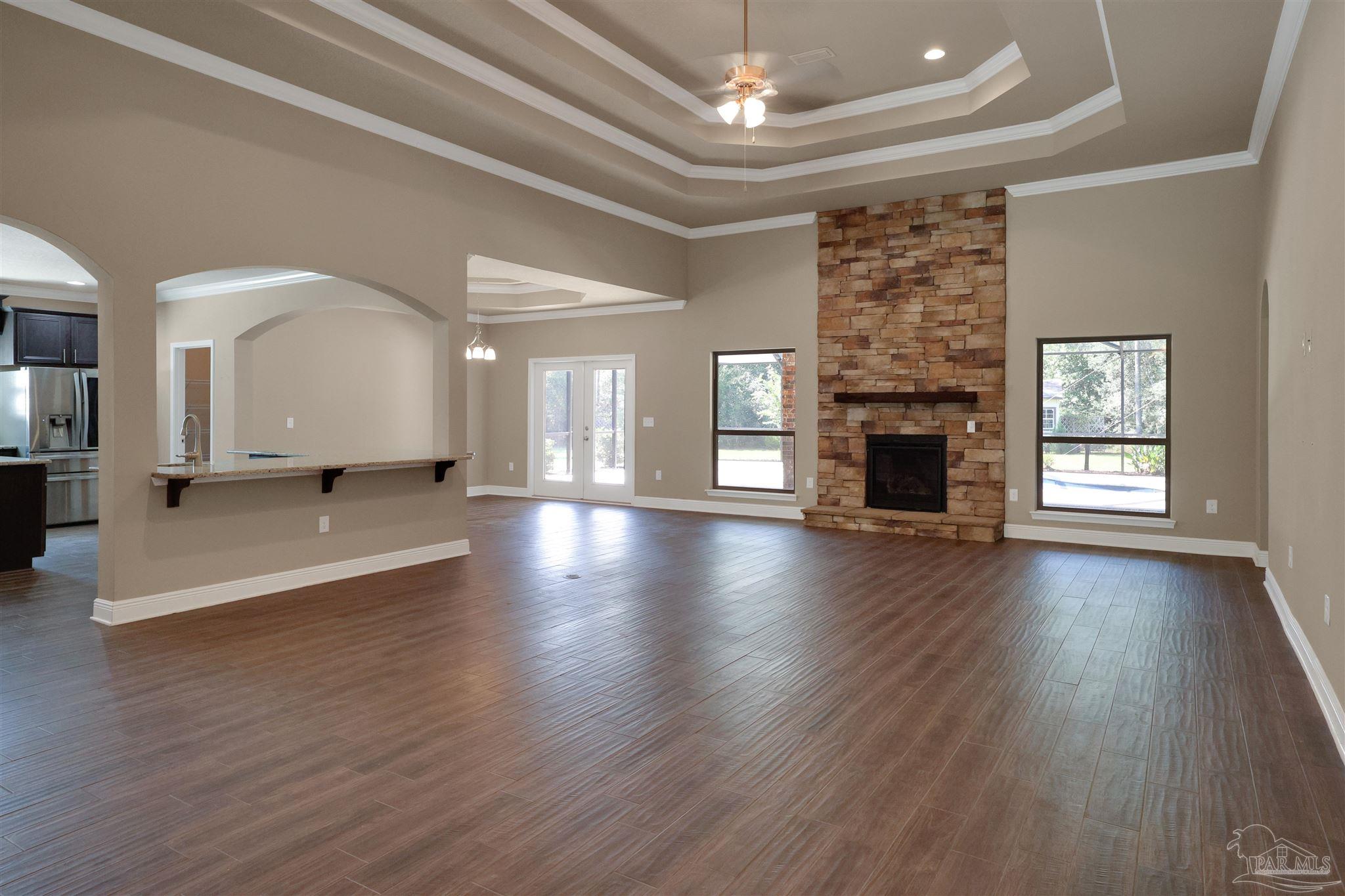 5847 Mossy Creek Lane Pace, FL 32571 - Photo 7 of 50 an empty room with wooden floor and a fireplace
