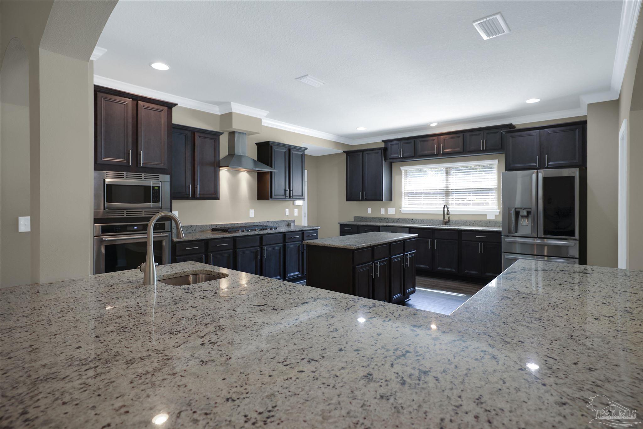 5847 Mossy Creek Lane Pace, FL 32571 - Photo 9 of 50 a large kitchen with kitchen island granite countertop a large counter top stainless steel appliances and cabinets