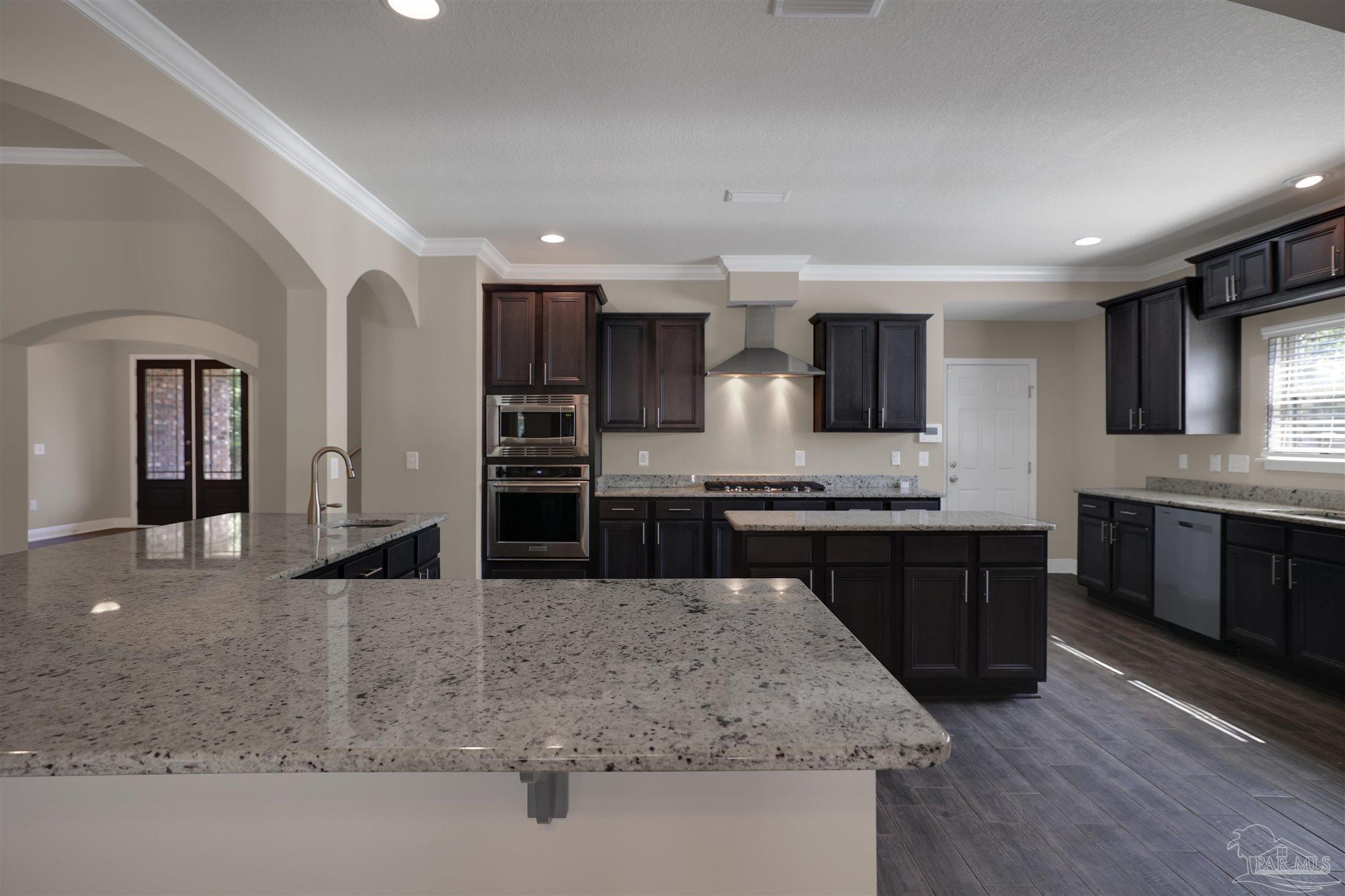5847 Mossy Creek Lane Pace, FL 32571 - Photo 10 of 50 a large kitchen with granite countertop a large counter top stainless steel appliances and cabinets
