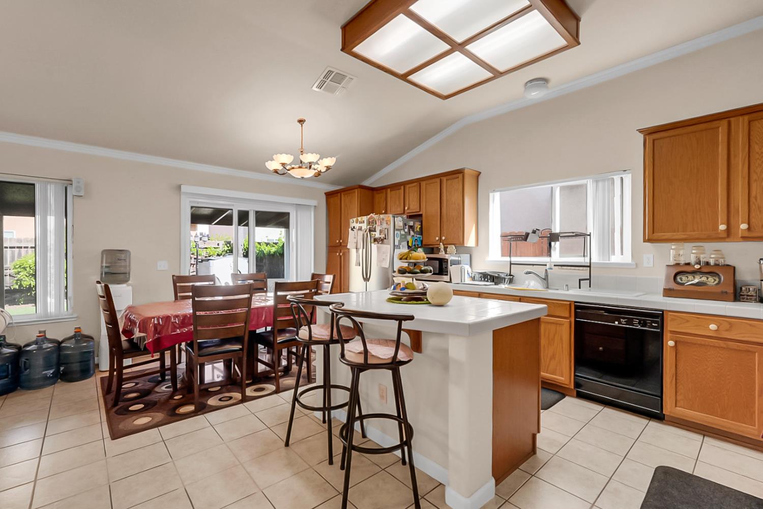 5432 Roselena Way Keyes, CA 95328 - Photo 6 of 16 a kitchen with a dining table chairs sink and white stainless steel appliances
