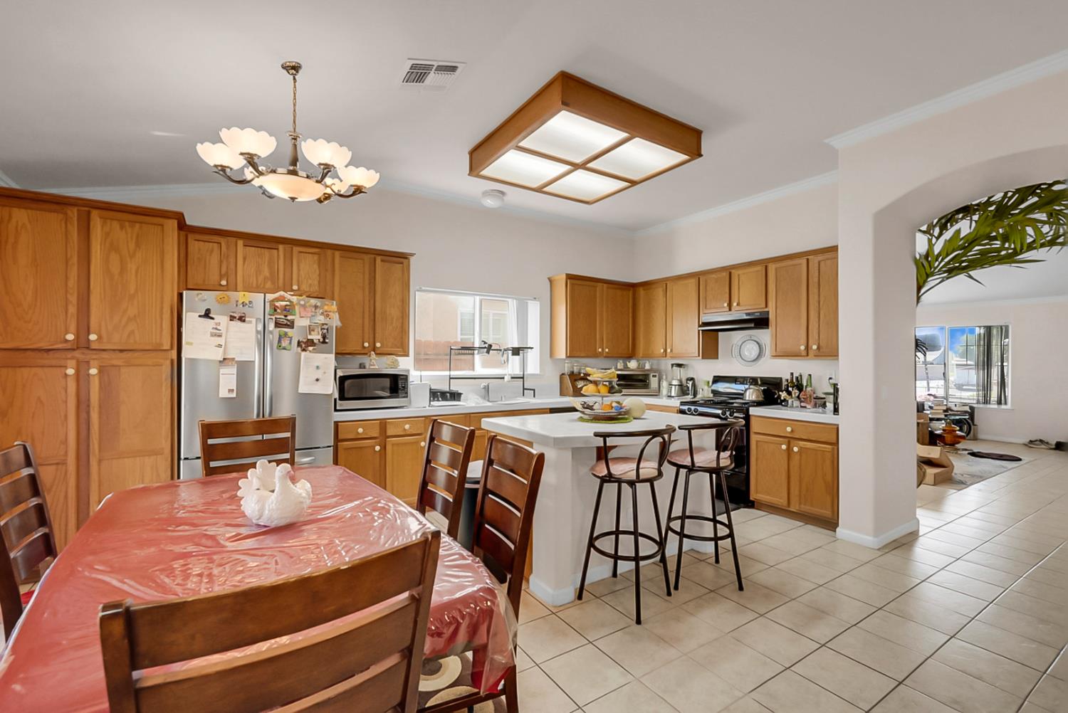 5432 Roselena Way Keyes, CA 95328 - Photo 9 of 16 a kitchen that has a lot of cabinets a sink a stove a dining table and chairs