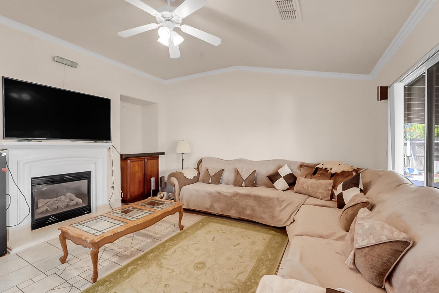 5432 Roselena Way Keyes, CA 95328 - Photo 10 of 16 a living room with furniture a fireplace and a flat screen tv