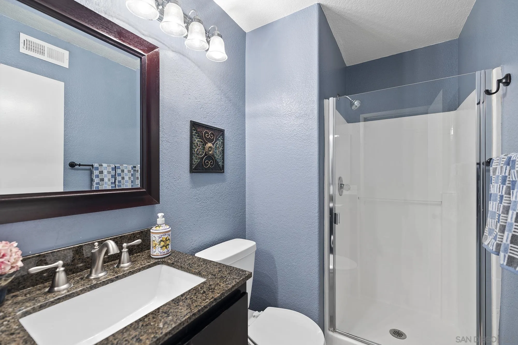 31450 Corte Rimola Temecula, CA 92592 - Photo 13 of 31 a bathroom with a granite countertop sink toilet a mirror a vanity and shower