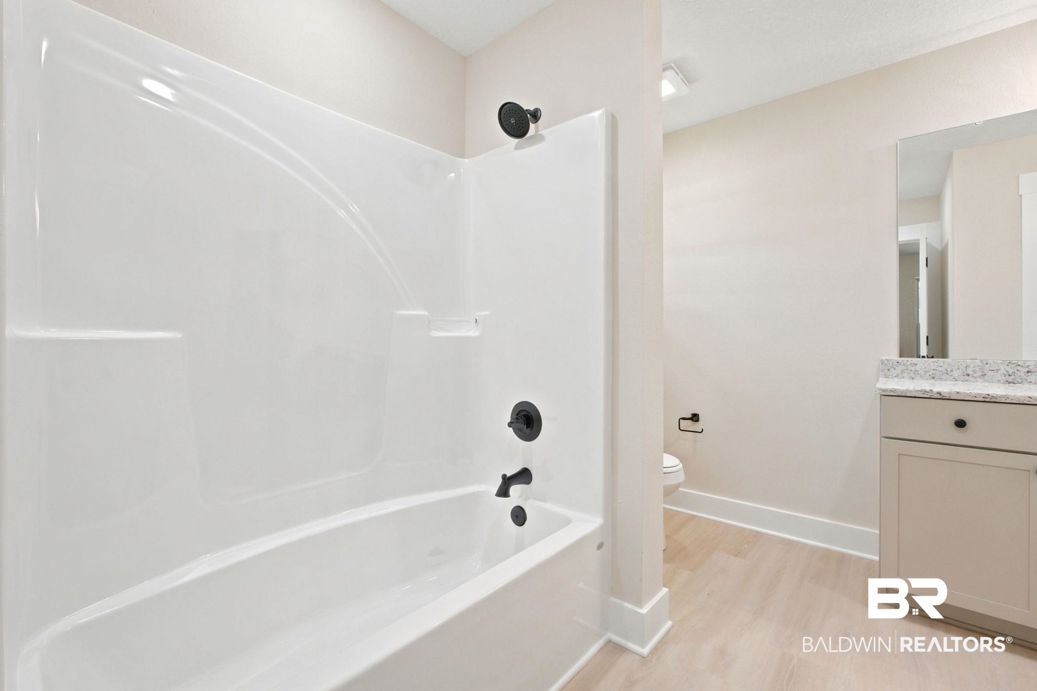 32656 Arbor Ridge Circle Lillian, AL 36549 - Photo 26 of 56 Bathroom featuring a white tub-shower combination with matte black fixtures, a single vanity with a light-colored countertop, and light wood-finish flooring