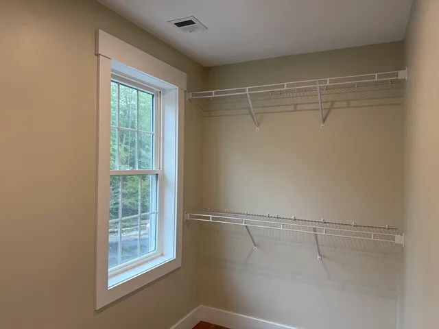 a view of a room with racks on the wall and a window