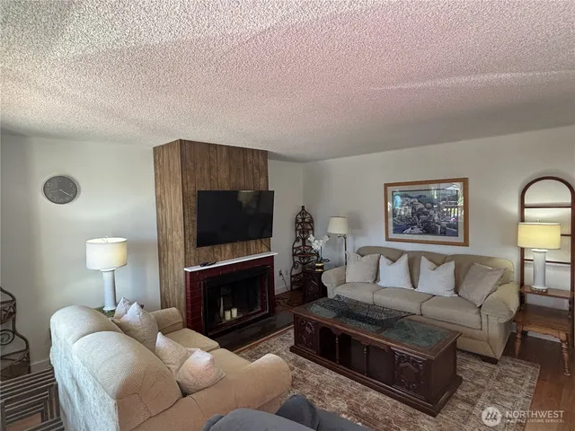 a living room with furniture a fireplace and a flat screen tv