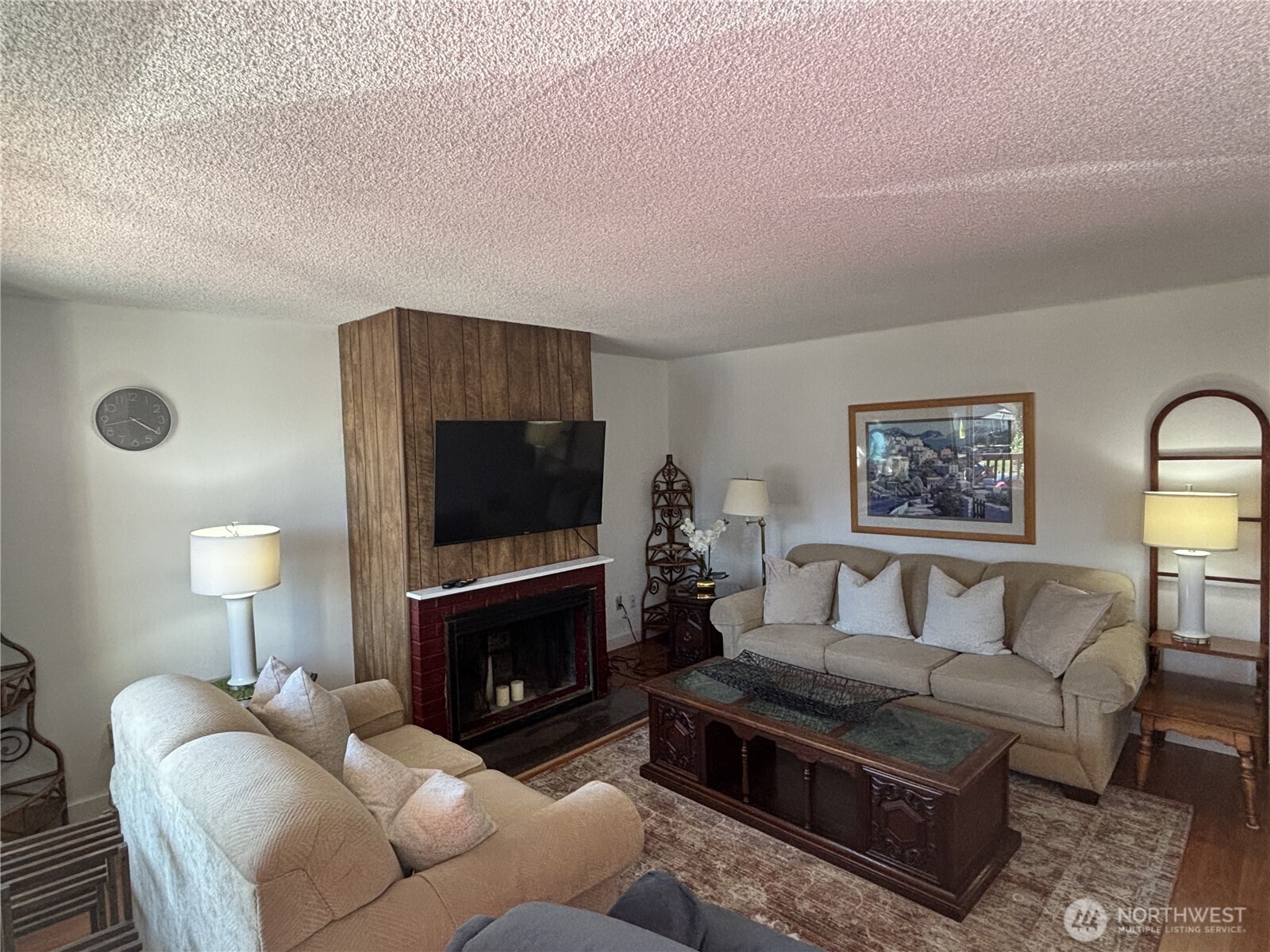 7265 East Harrison Street, Unit A Port Orchard, WA 98366 - Photo 7 of 17 a living room with furniture a fireplace and a flat screen tv