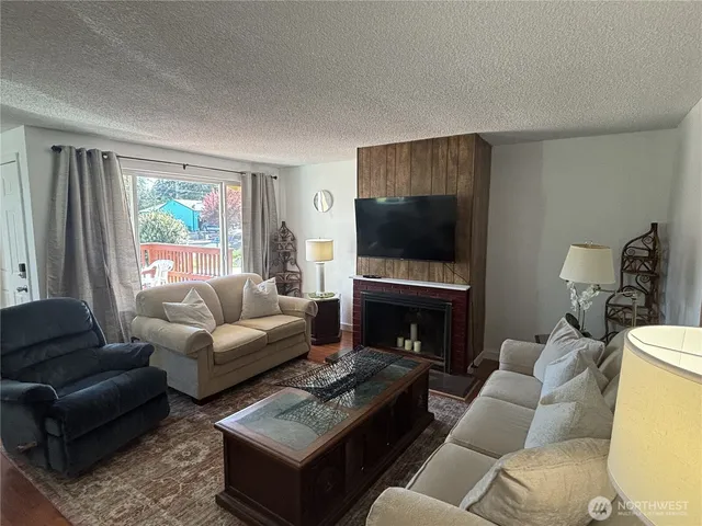 a living room with furniture a flat screen tv and a fireplace