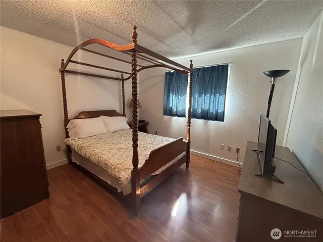 a bedroom with a bed and wooden floor