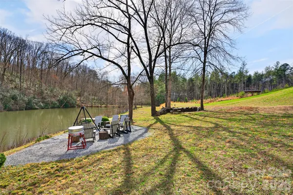 a view of a lake with a table and chairs under an umbrella