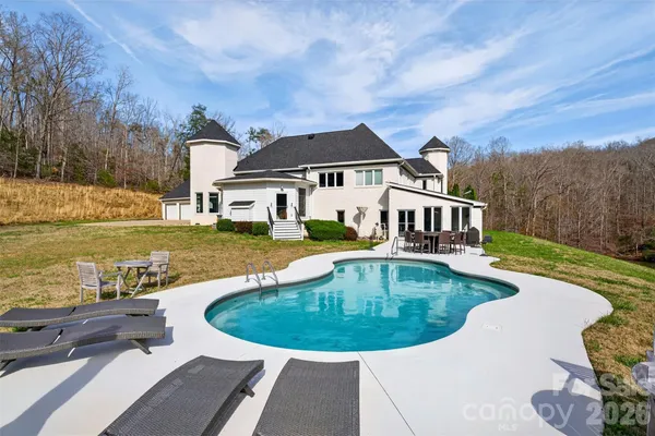 a view of a house with swimming pool and sitting area