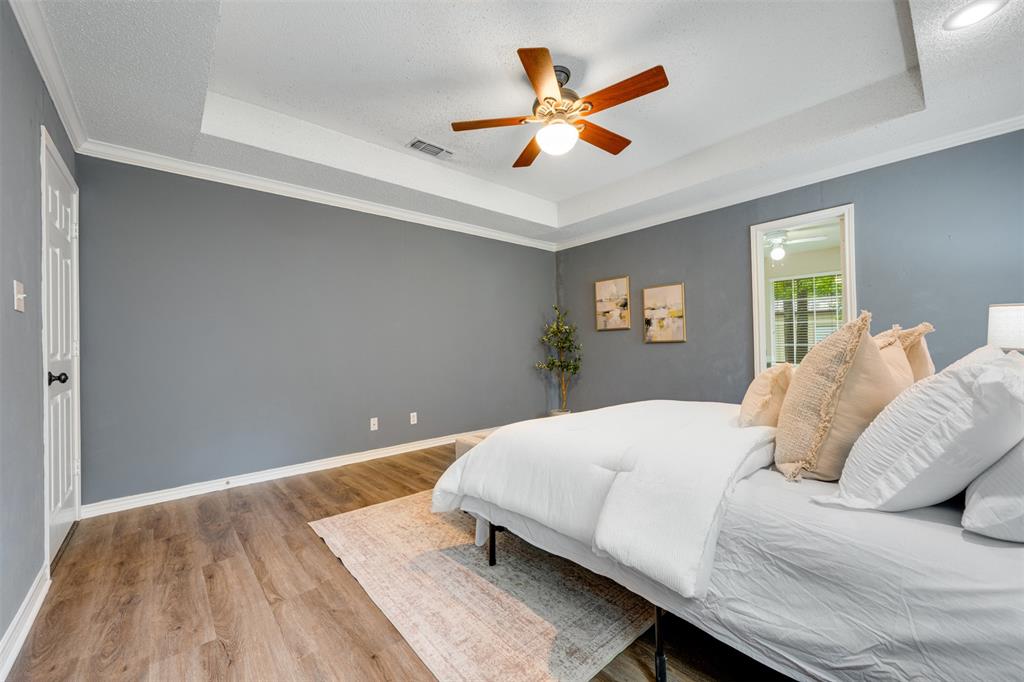 248 Butternut Lane Powderly, TX 75473 - Photo 18 of 40 a bedroom with a large bed and a ceiling fan