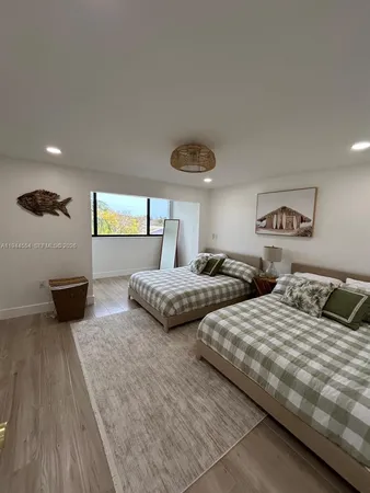 a bedroom with two beds and a large window