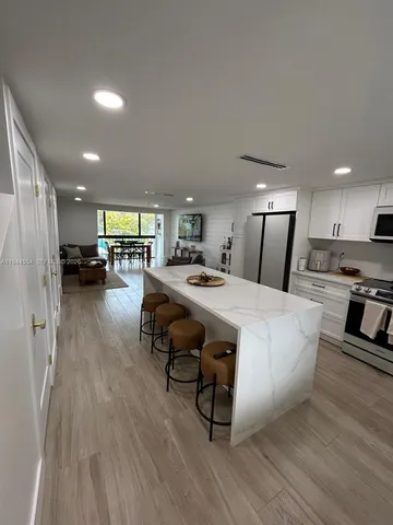 a large kitchen with a table chairs refrigerator and stove