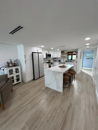 a large kitchen with stainless steel appliances kitchen island a large counter top and a stove