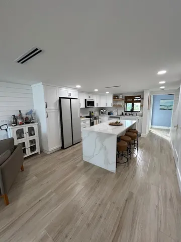 a large kitchen with stainless steel appliances kitchen island a large counter top and a stove