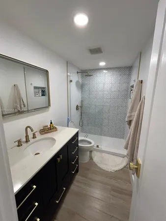 a bathroom with a double vanity sink toilet mirror and shower