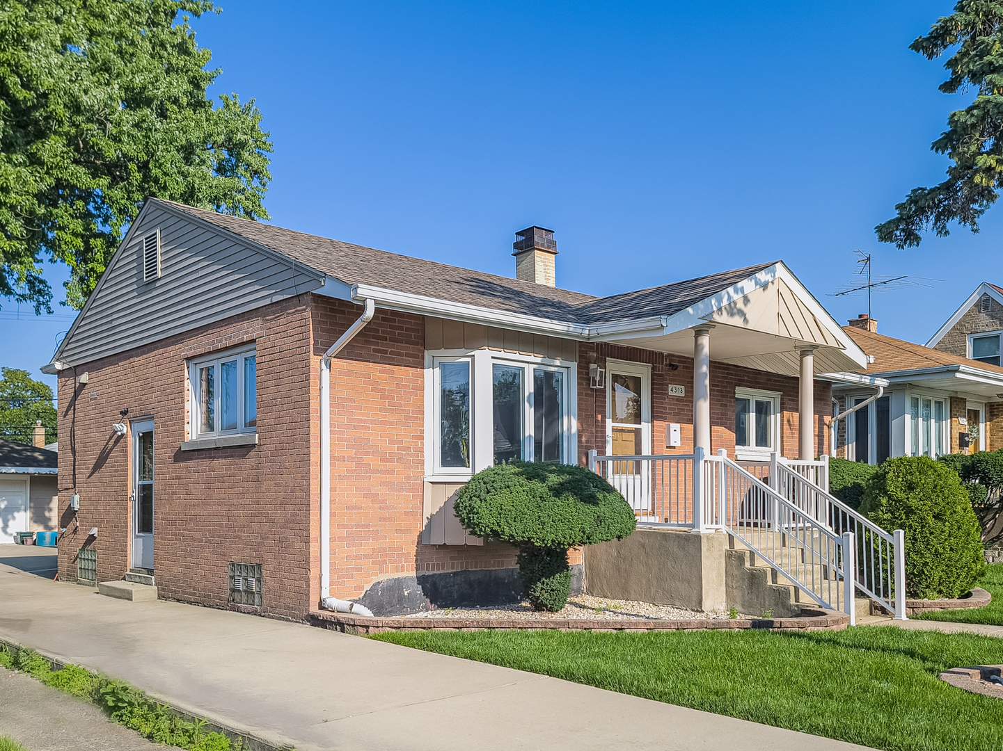 a front view of a house with a yard and potted plants
