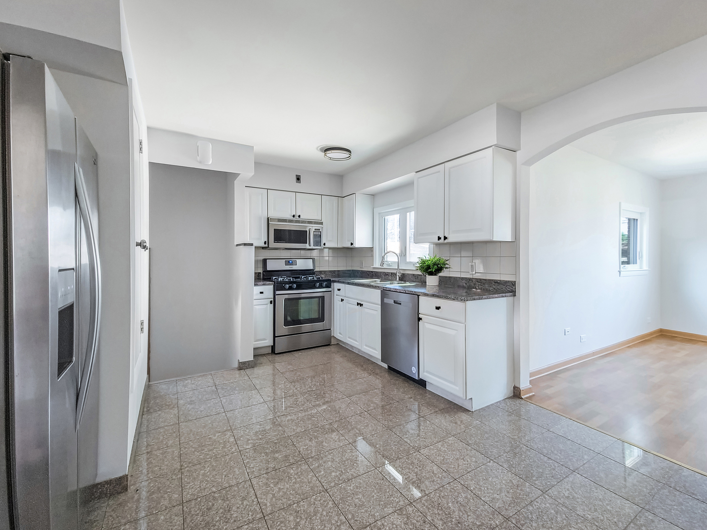 4313 Ruby Street Schiller Park, IL 60176 - Photo 4 of 25 a kitchen with white cabinets and stainless steel appliances