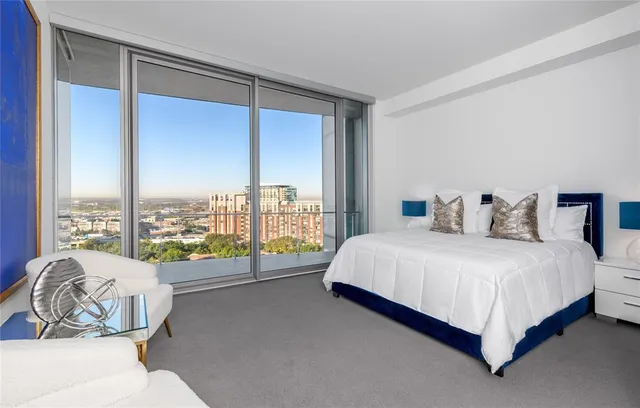 a bedroom with a bed and a large window with outer view