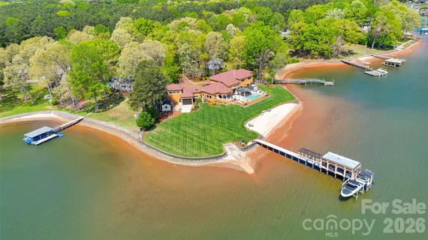 an aerial view of a house with a yard and lake view
