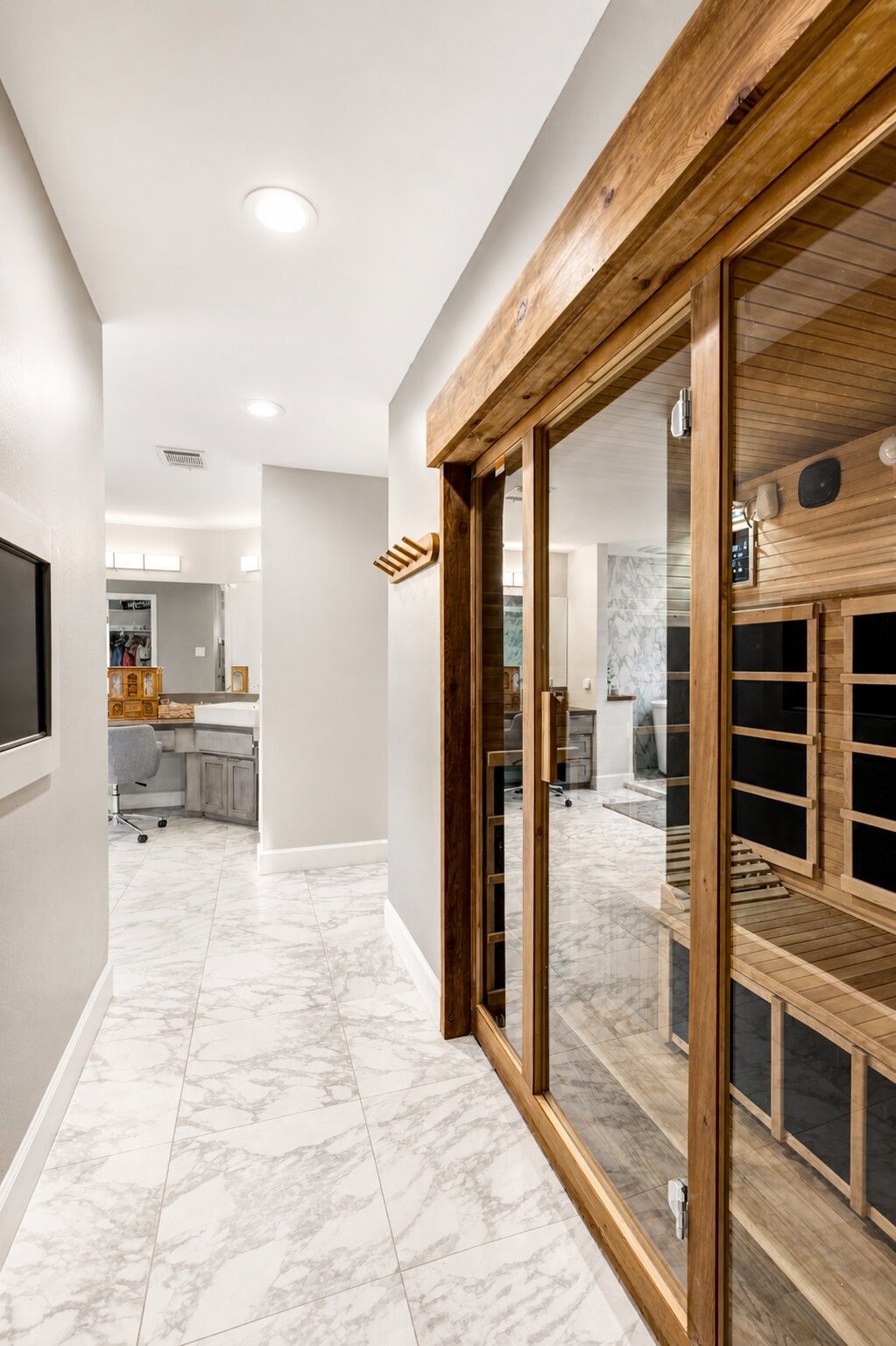 201 Vanderpool Lane, Unit 130 Houston, TX 77024 - Photo 24 of 41 The primary bath includes a dry sauna with a glass front, premium wooden interior and built-in TV on the opposite wall.