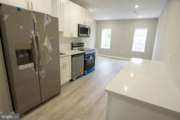 a kitchen with stainless steel appliances a refrigerator and a stove top oven