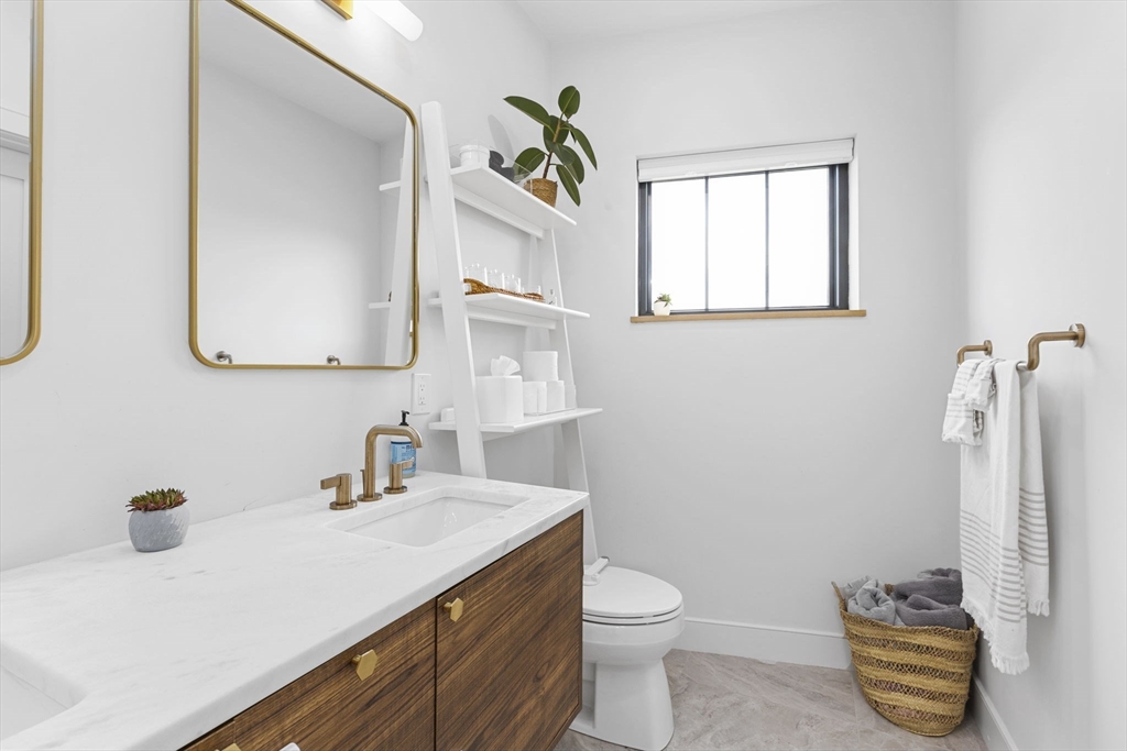 4 Payne Street, Unit ONE Boston, MA 02122 - Photo 11 of 18 a bathroom with a sink a toilet and mirror