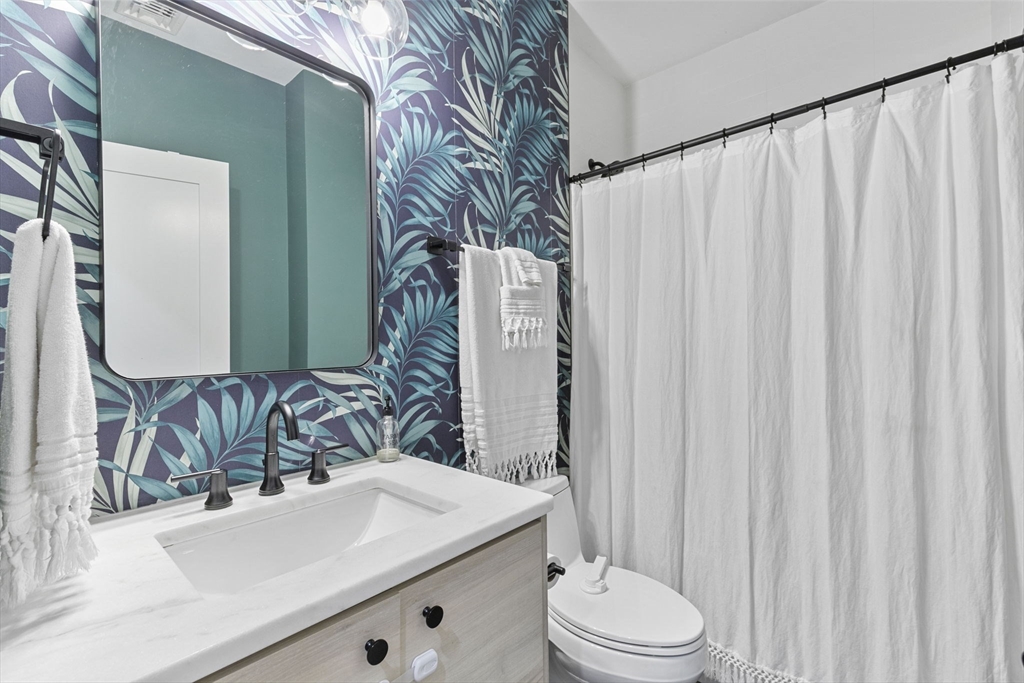 4 Payne Street, Unit ONE Boston, MA 02122 - Photo 15 of 18 a bathroom with a sink a toilet and a mirror