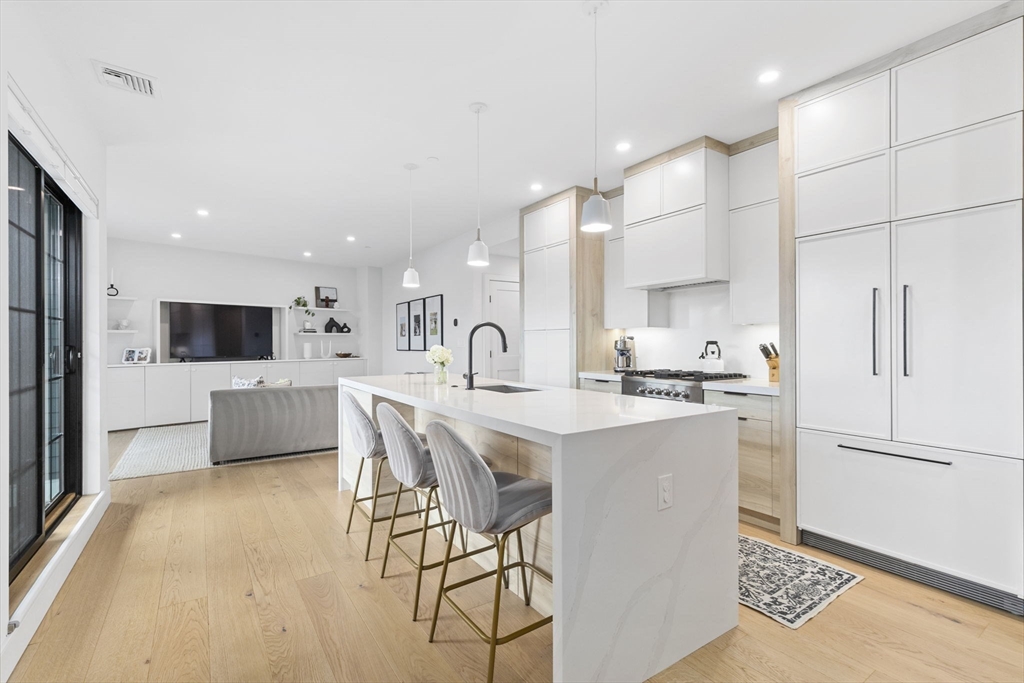 4 Payne Street, Unit ONE Boston, MA 02122 - Photo 5 of 18 a kitchen with kitchen island stainless steel appliances a sink a stove a refrigerator and cabinets