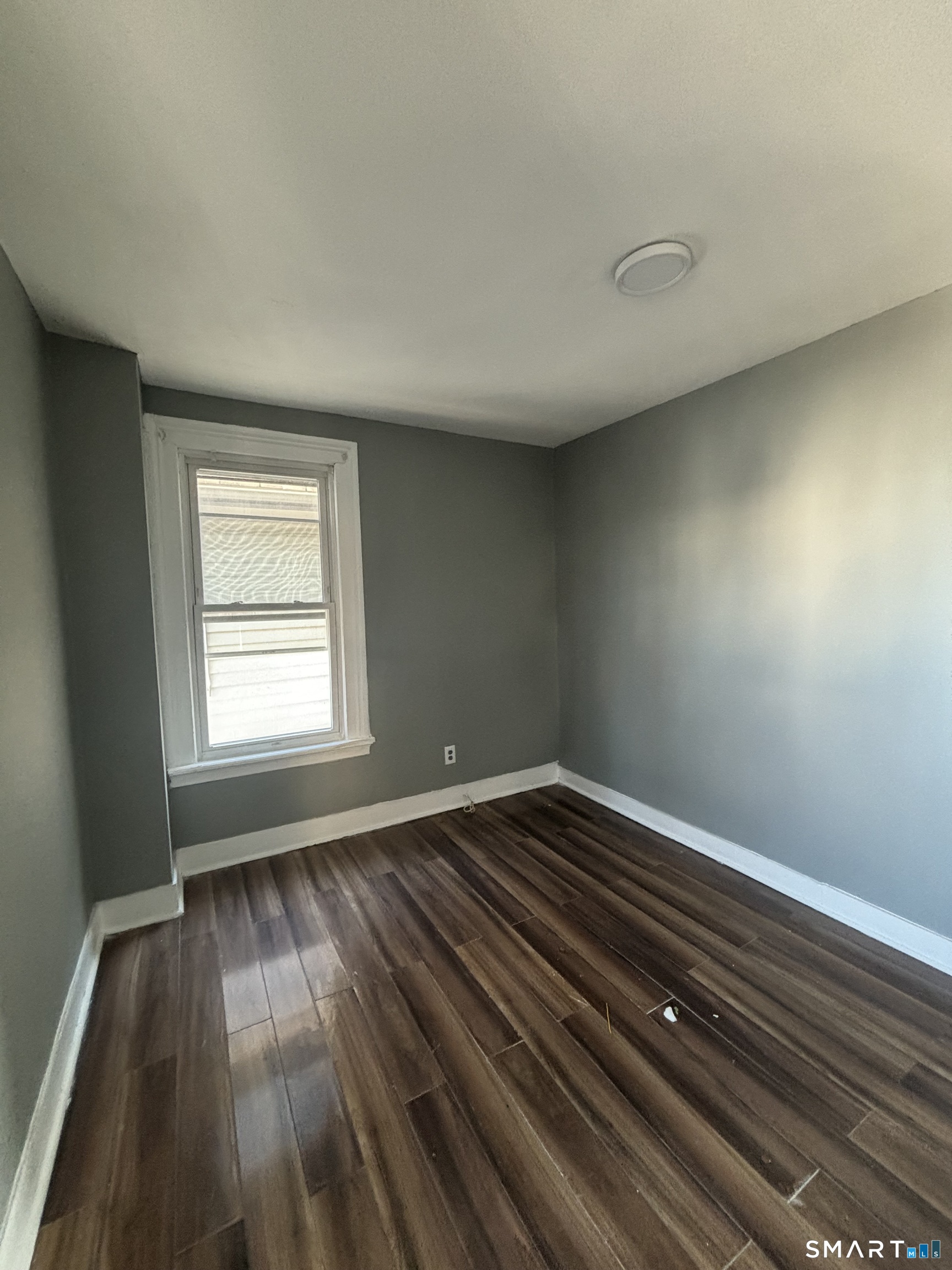 295 Shelton Street Bridgeport, CT 06608 - Photo 5 of 5 an empty room with wooden floor and windows