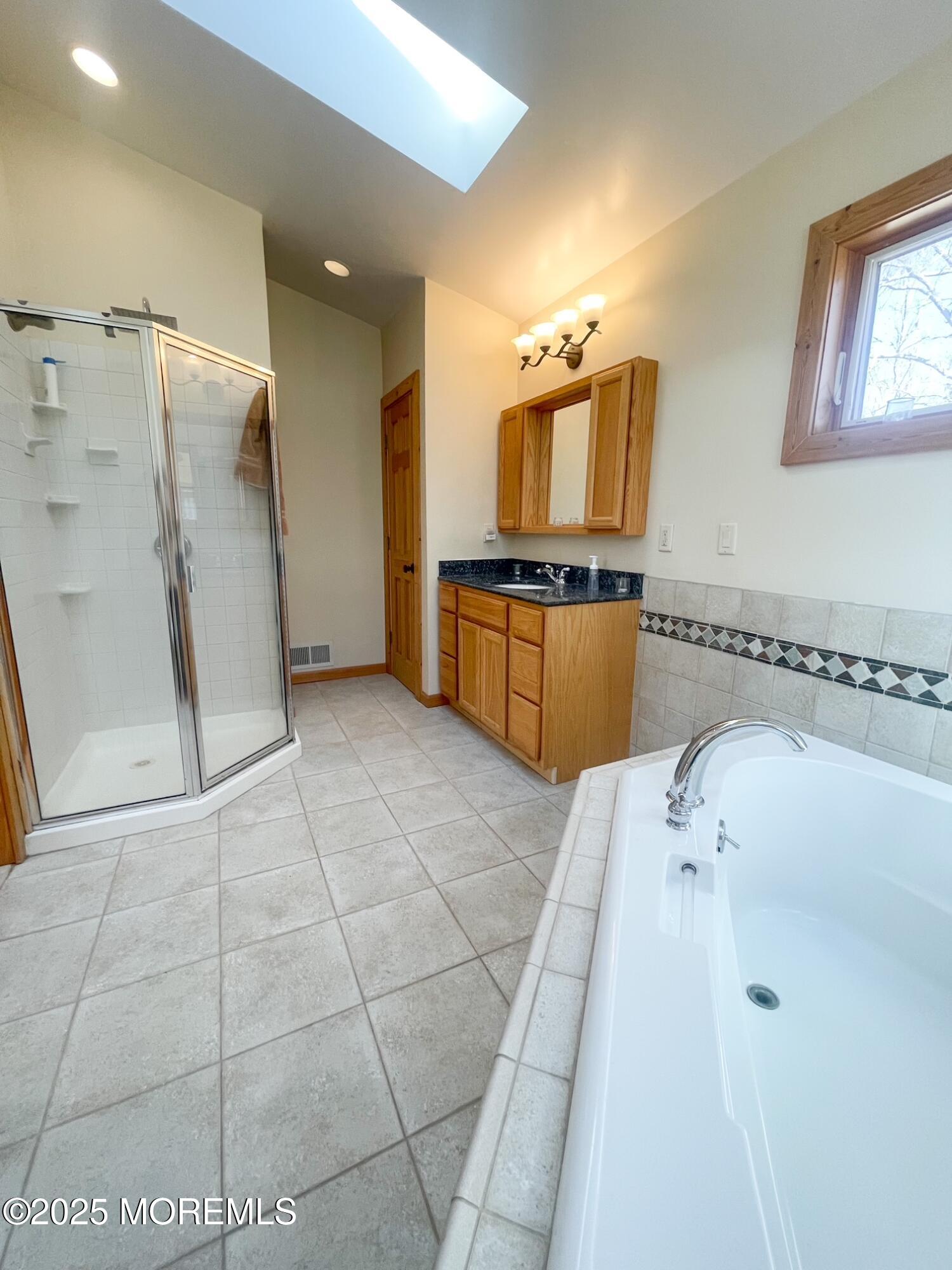 10 Spring Road Clarksburg, NJ 08510 - Photo 16 of 27 a large bathroom with a tub a sink and a mirror