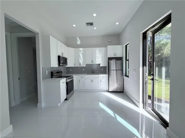 a large kitchen with cabinets and stainless steel appliances