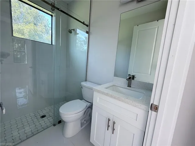 a bathroom with a granite countertop sink toilet and shower