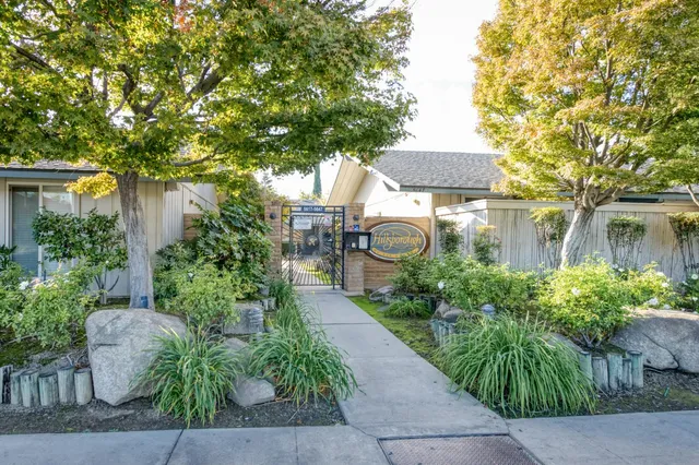 a front view of a house with a yard and fountain