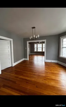 a view of empty room with window and wooden floor