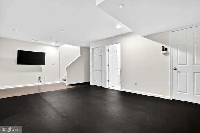 an empty room with wooden floor and white walls