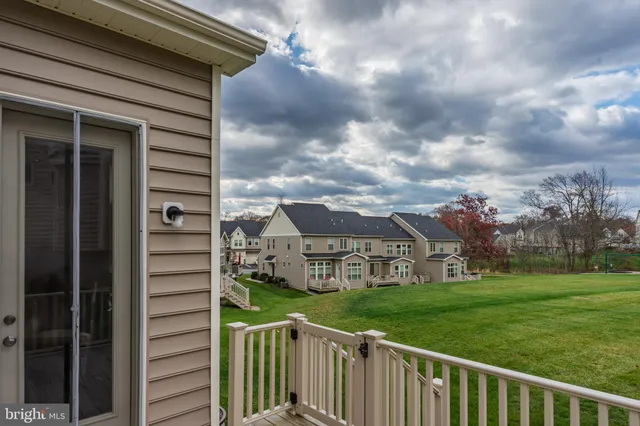a view of backyard with barbeque grill and wooden fence