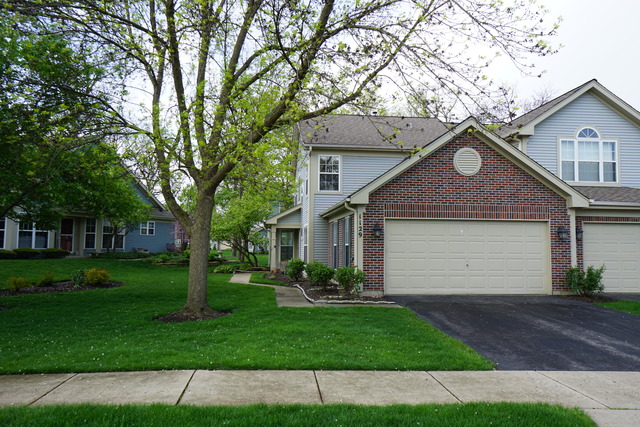 a front view of a house with a garden and trees