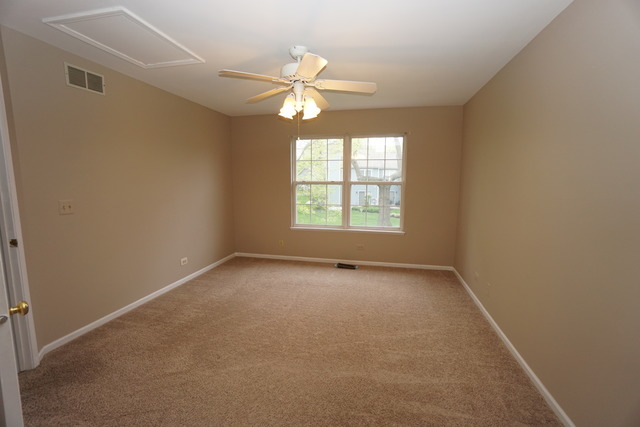 1129 Coldspring Road Elgin, IL 60120 - Photo 16 of 18 an empty room with windows and chandelier fan