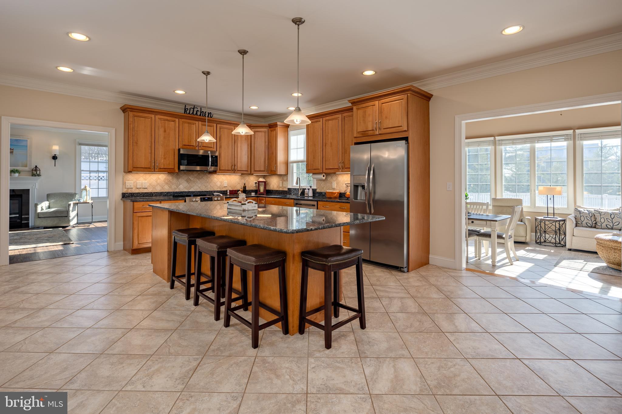 115 Cedar Road Chester, MD 21619 - Photo 9 of 71 a kitchen with stainless steel appliances granite countertop a table chairs and a refrigerator