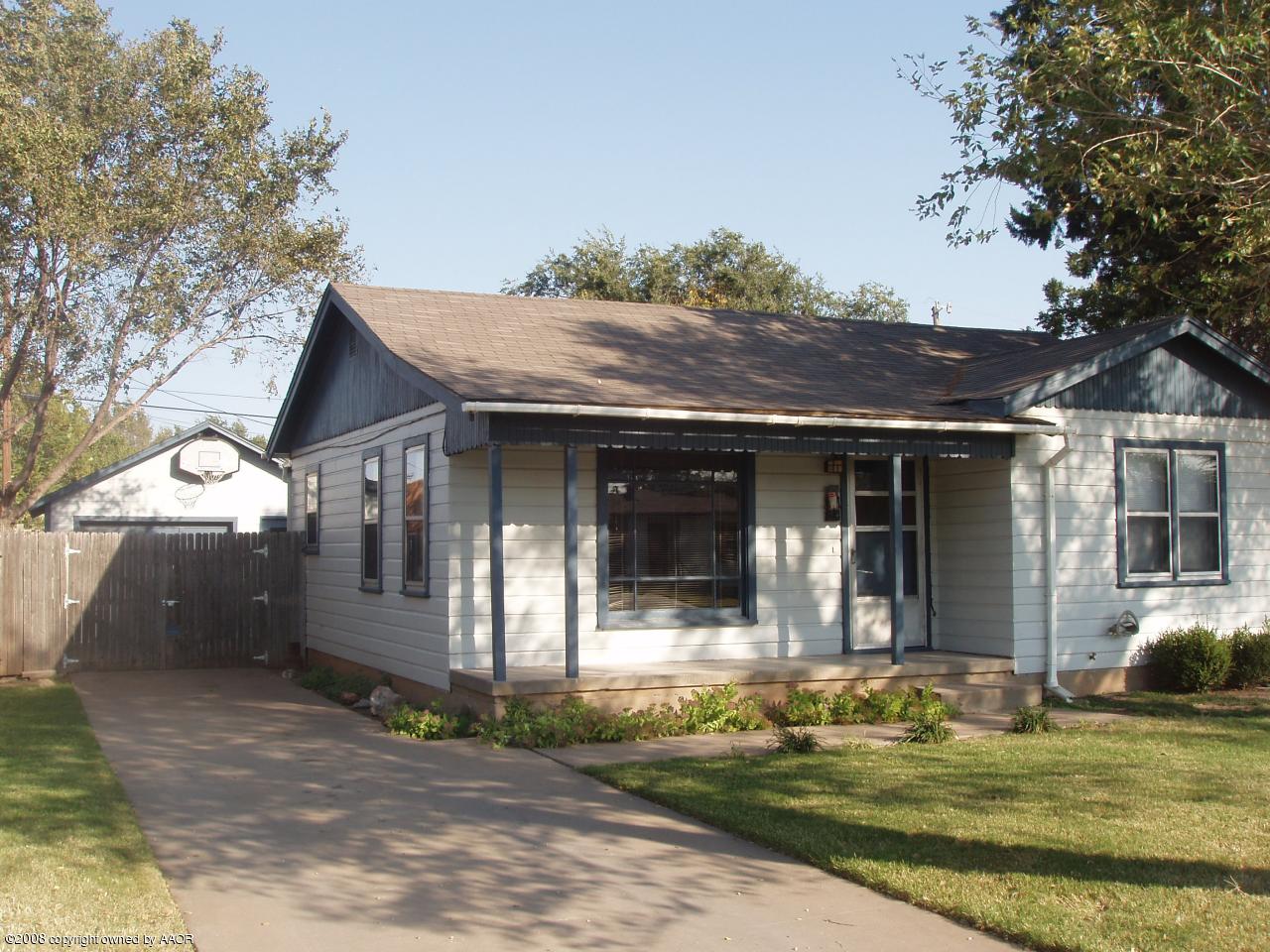 4303 South Jackson Street Amarillo, TX 79110 - Photo 2 of 18 a view of a white house with large windows and a small yard