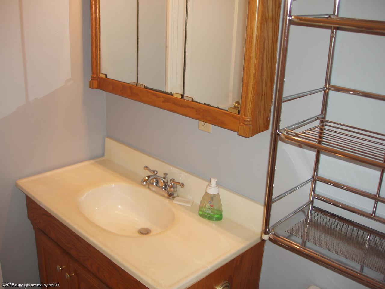4303 South Jackson Street Amarillo, TX 79110 - Photo 12 of 18 a bathroom with a sink and a mirror