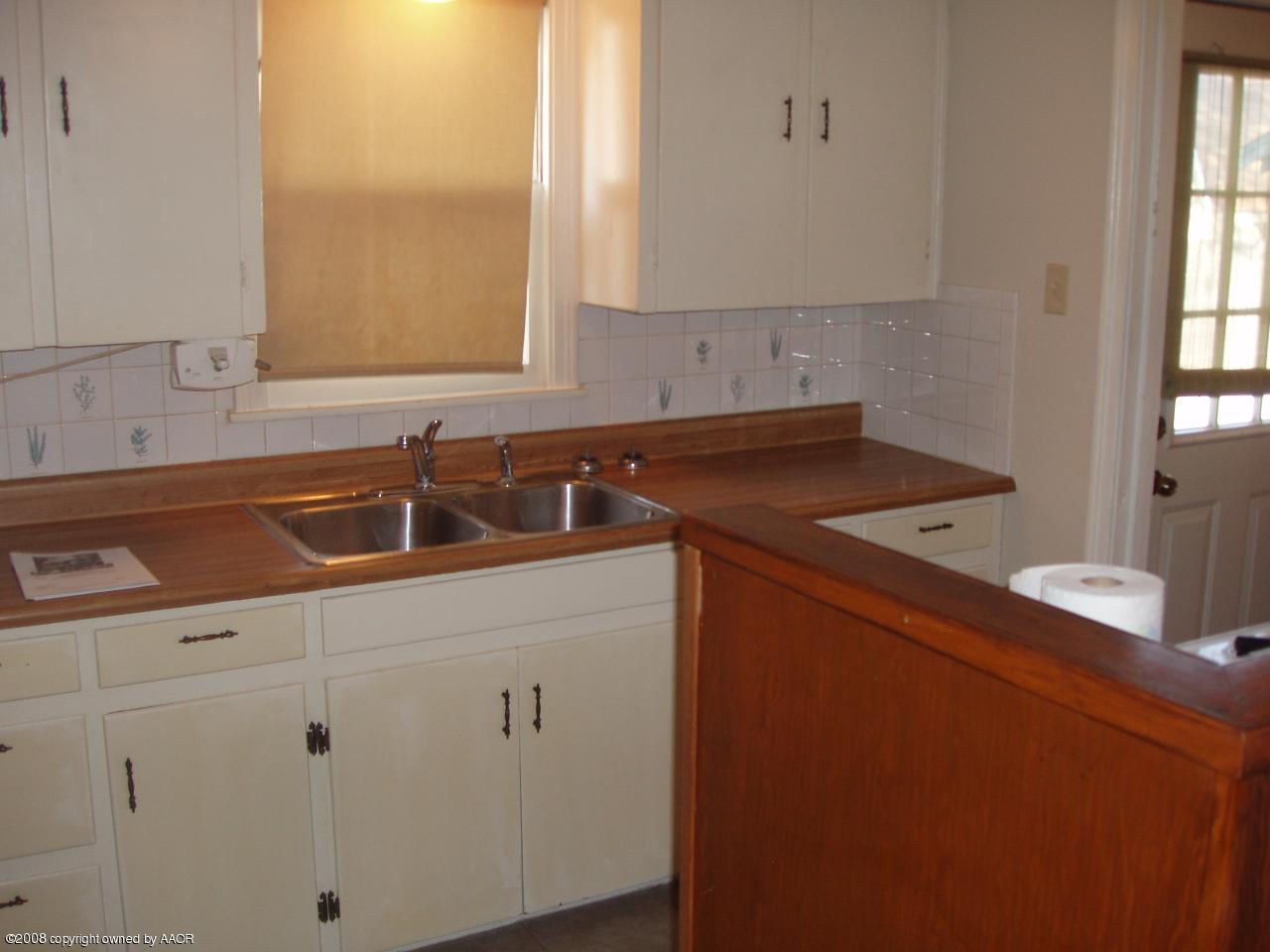 4303 South Jackson Street Amarillo, TX 79110 - Photo 7 of 18 a kitchen with a sink cabinets and window
