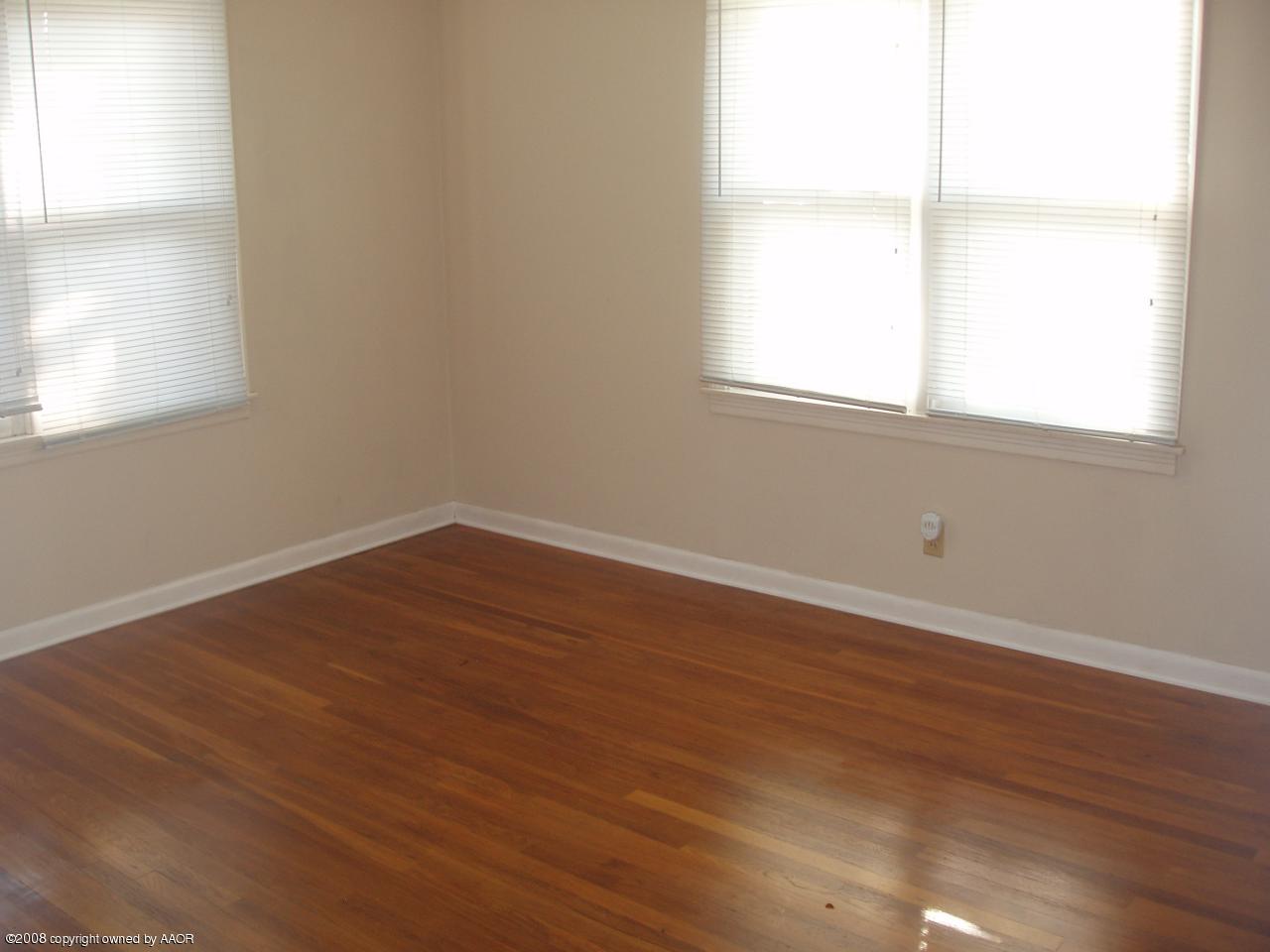 4303 South Jackson Street Amarillo, TX 79110 - Photo 10 of 18 an empty room with wooden floor and windows