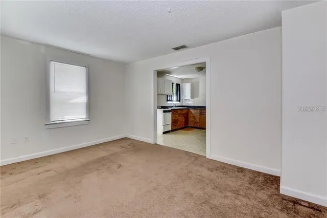 an empty room with a fireplace and windows