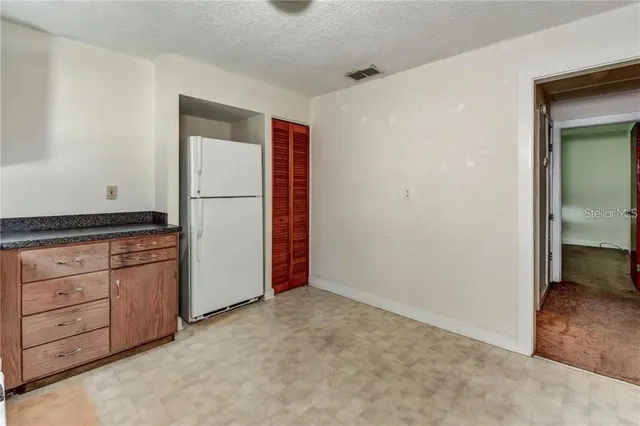 a kitchen with granite countertop cabinets and refrigerator