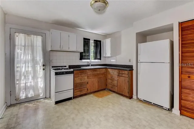 a kitchen with white cabinets and white appliances