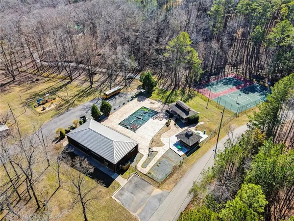 an aerial view of a house with swimming pool and large trees